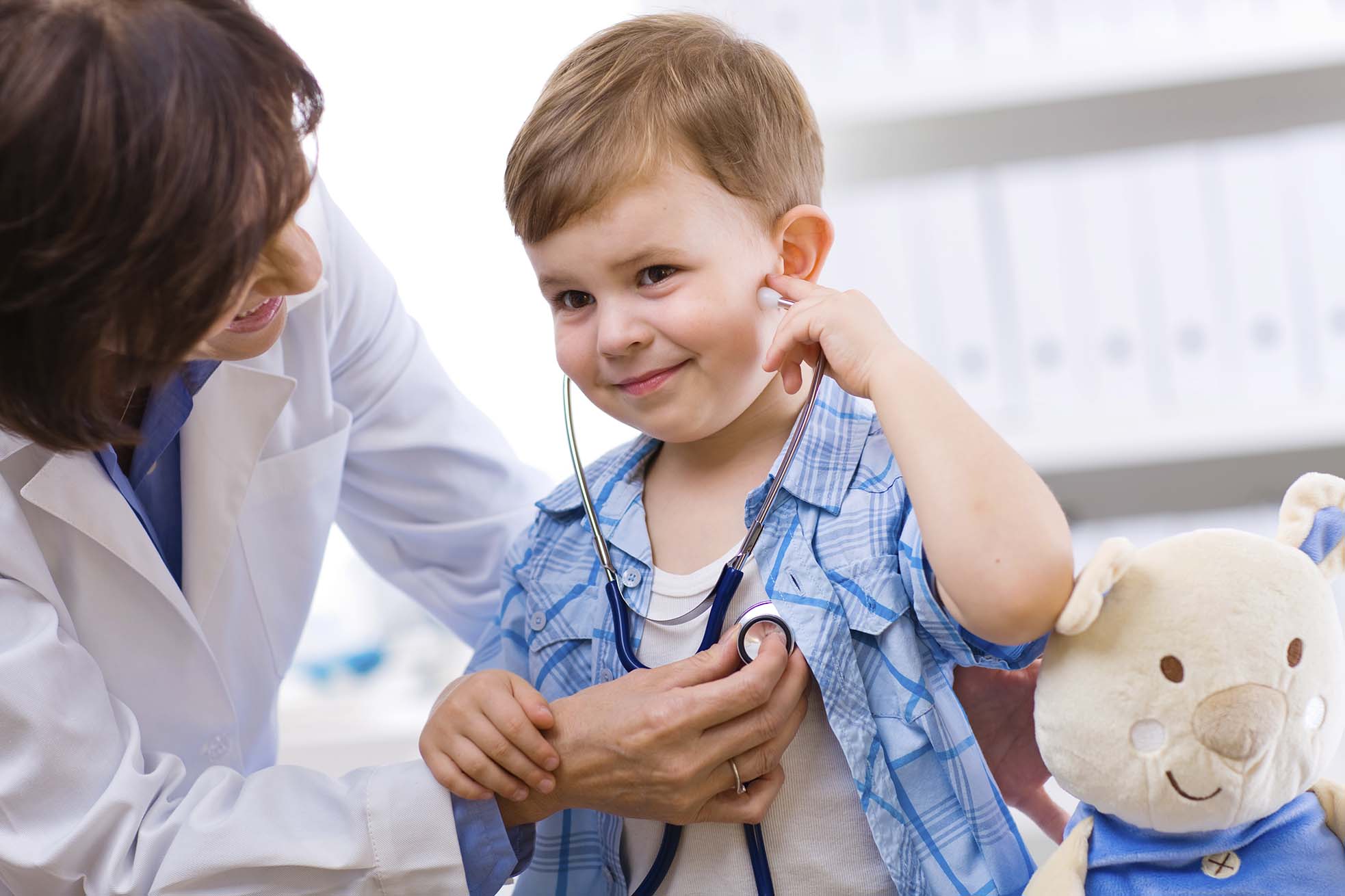 Kid wearing stethoscope at doctor's office listening to his own heart