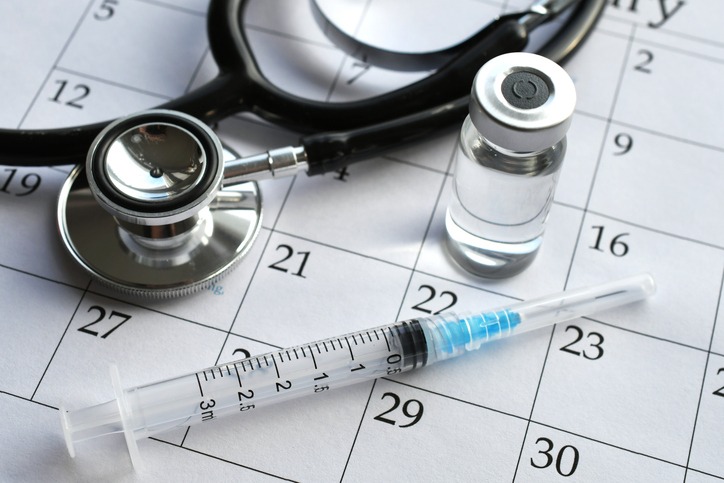Calendar with vaccine bottle and syringe to symbolize the MMR Vaccine Schedule