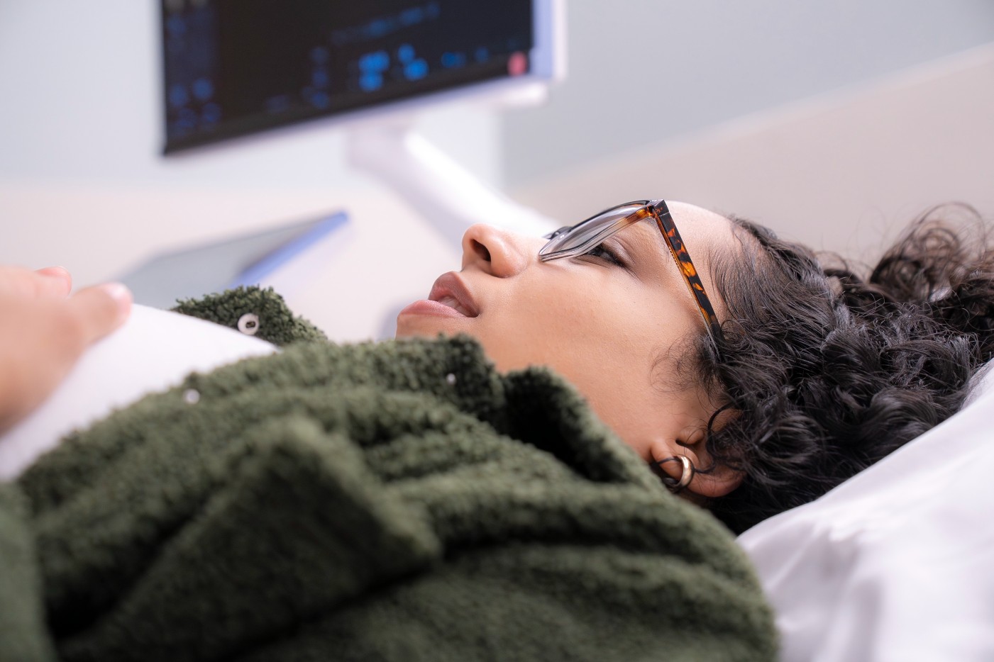 Mom lying comfortably while getting an ultrasound for prenatal genetic testing at a maternal-fetal medicine office