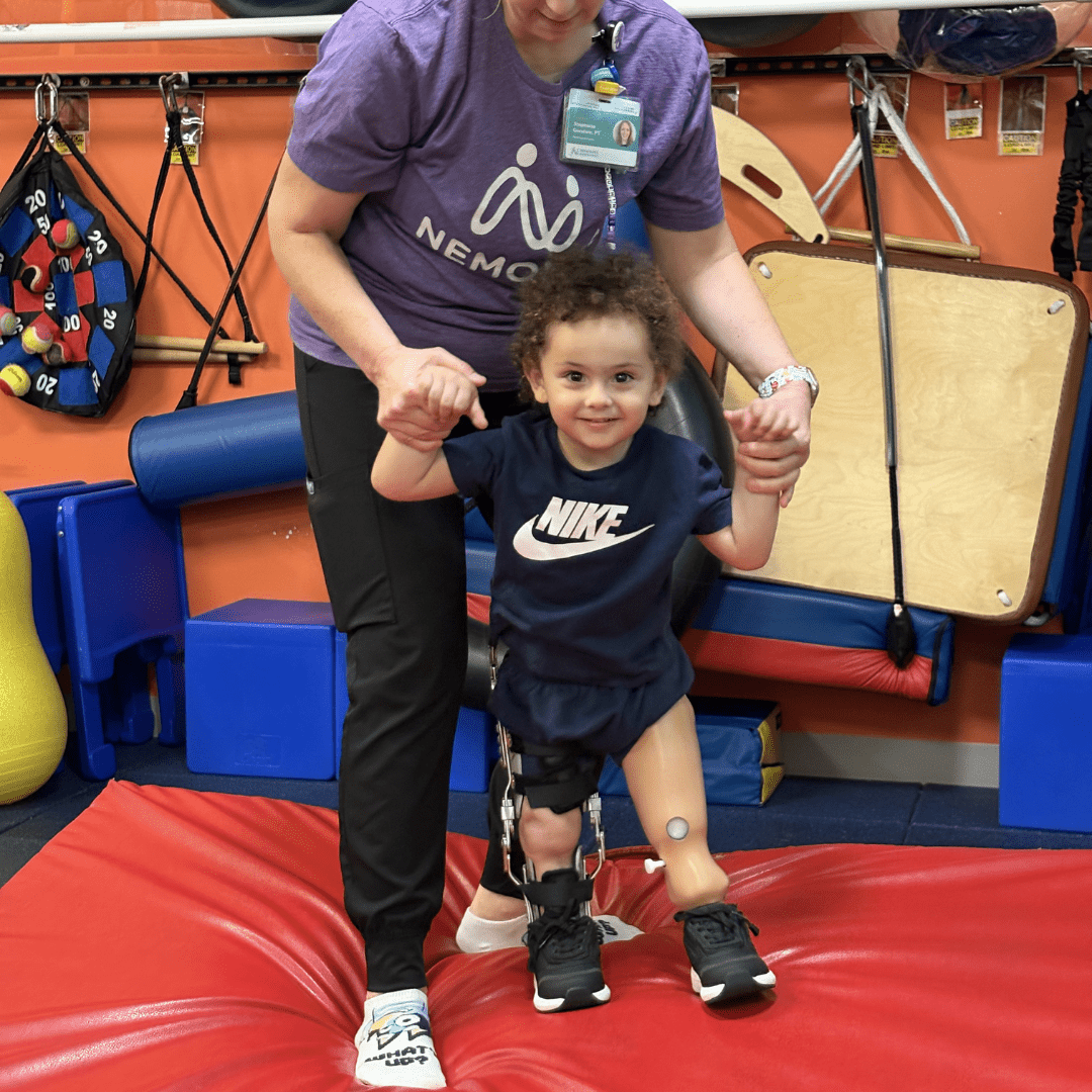 Boy with prosthetic leg participates in physical therapy